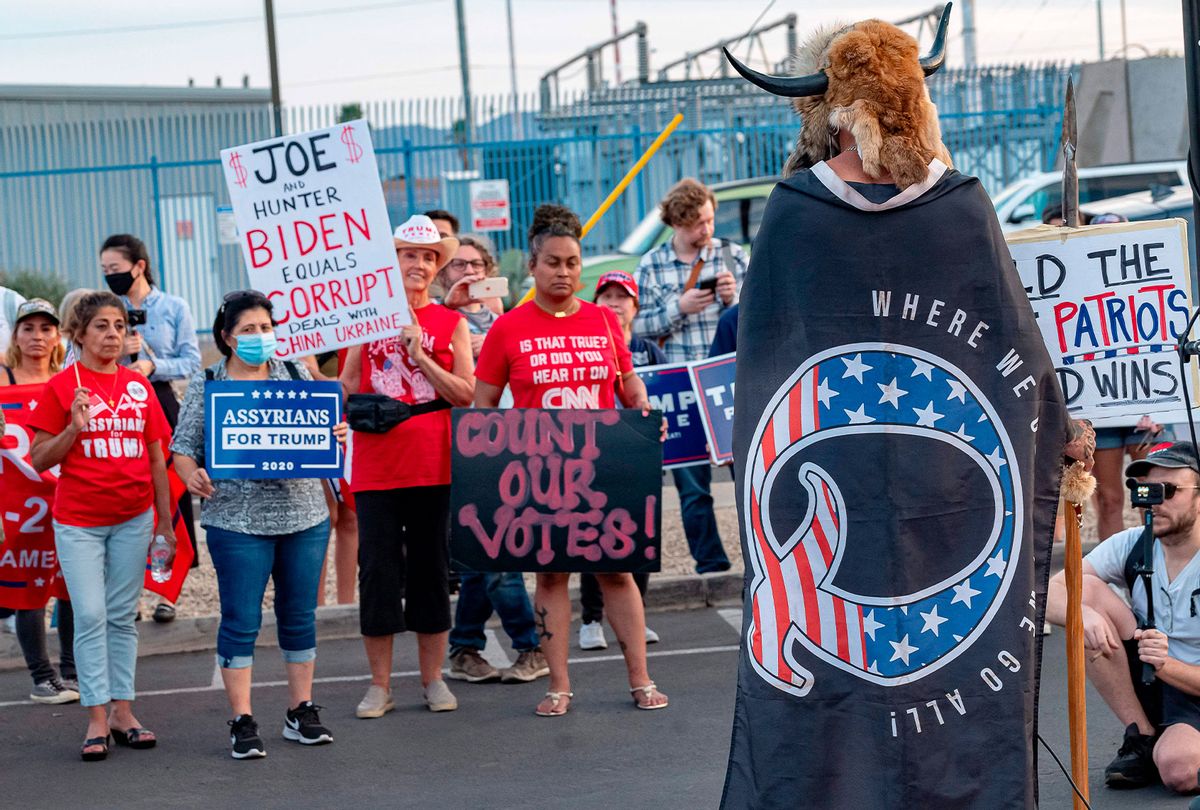 Jake A, 33, aka Yellowstone Wolf, from Phoenix, wrapped in a QAnon flag, addresses supporters of US President Donald Trump as they protest outside the Maricopa County Election Department as counting continues after the US presidential election in Phoenix, Arizona, on November 5, 2020. (OLIVIER TOURON/AFP via Getty Images)