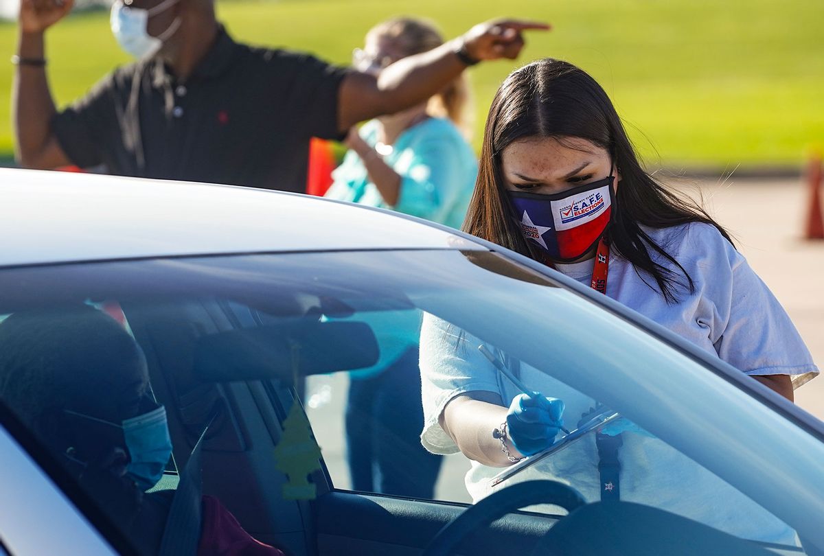 An election worker accepts mail in ballot from a voter at drive-through mail ballot drop off site at NRG Stadium on October 7, 2020 in Houston, Texas. Gov. Gregg Abbott issued an executive order limiting each Texan county to one mail ballot drop-off site due to the pandemic. (Go Nakamura/Getty Images)