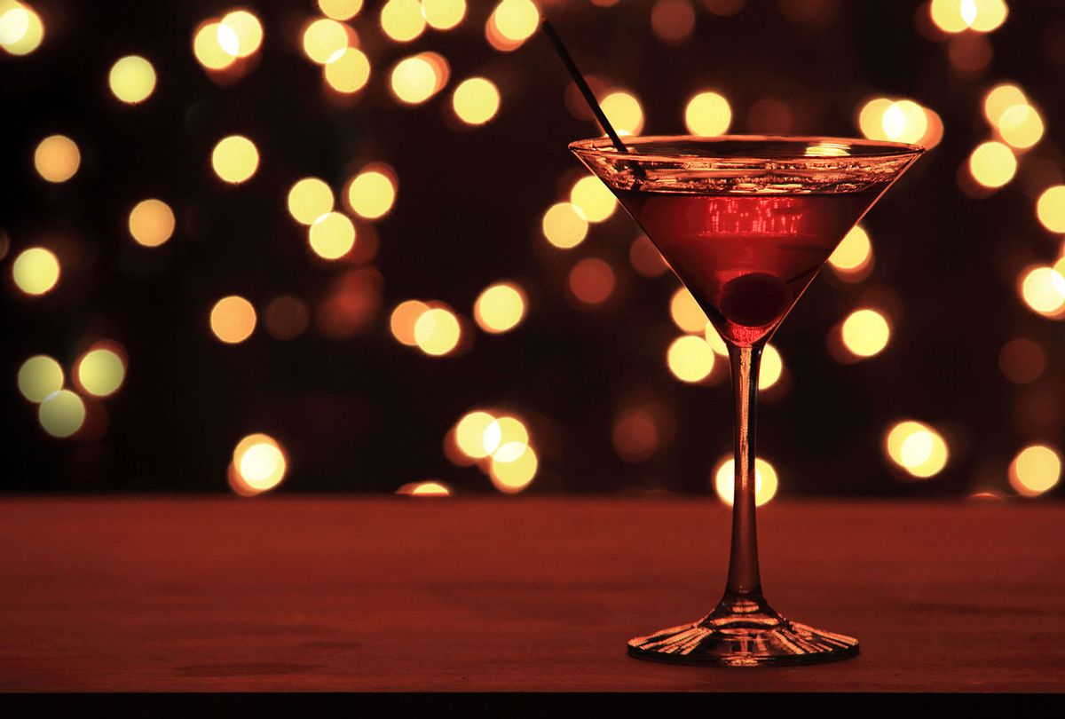 Christmas Cherry Martini on bar top counter with christmas lights in background (Getty Images)