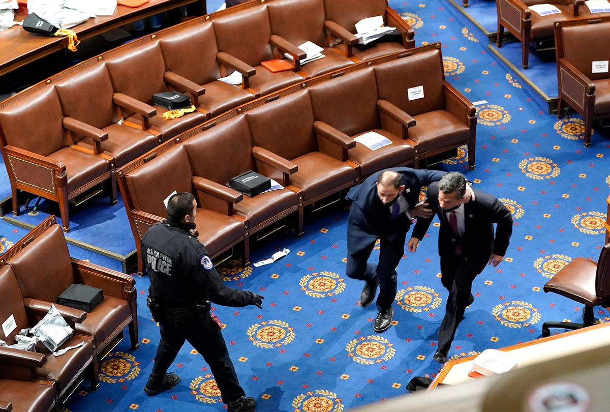 Members of congress run for cover as protesters try to enter the House Chamber during a joint session of Congress on January 06, 2021 in Washington, DC. Congress held a joint session today to ratify President-elect Joe Biden's 306-232 Electoral College win over President Donald Trump. A group of Republican senators said they would reject the Electoral College votes of several states unless Congress appointed a commission to audit the election results. (Drew Angerer/Getty Images)