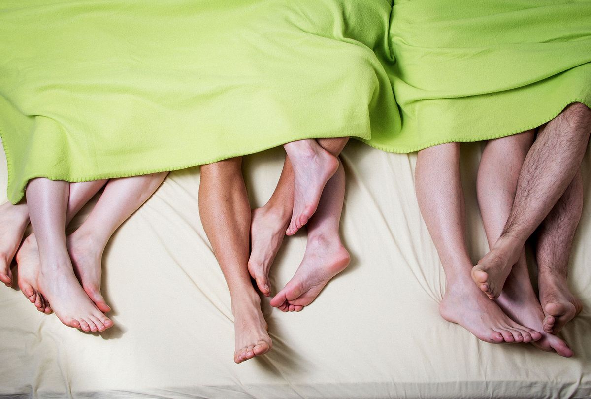 The feet of many people in bed (Getty Images)