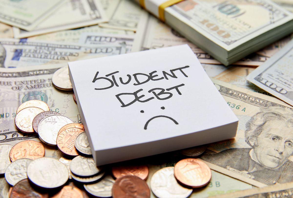 Student debt with sad face written on white sticky note on top of cash money with stack of money and coins (Getty Images)