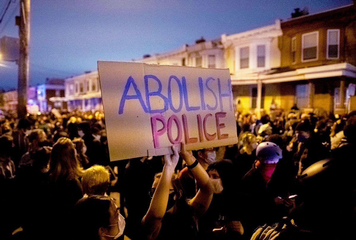 A demonstrator holds a placard reading "ABOLISH POLICE" during a protest near the location where Walter Wallace, Jr. was killed by two police officers on October 27, 2020 in Philadelphia, Pennsylvania. Protests erupted after the fatal shooting of 27-year-old Wallace Jr, who Philadelphia police officers claimed was armed with a knife. (Mark Makela/Getty Images)