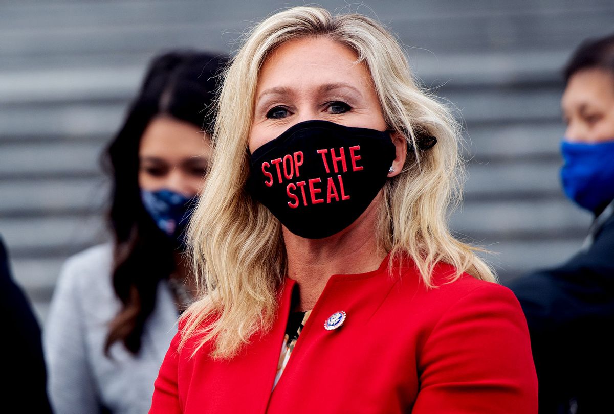 US Representative Marjorie Taylor Greene, Republican of Georgia, holds up a "Stop the Steal" mask while speaking with fellow first-term Republican members of Congress on the steps of the US Capitol in Washington, DC, January 4, 2021. (SAUL LOEB/AFP via Getty Images)