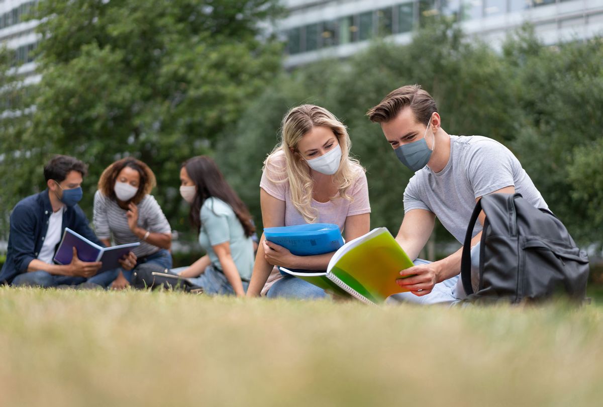 Students wearing face masks while studying outdoors (Getty Images)