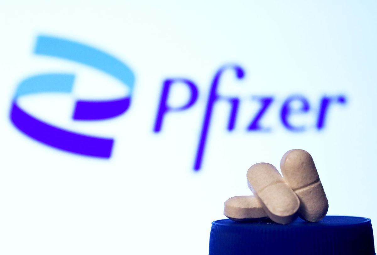 Medicine pills are seen with Pfizer logo displayed on a screen in the background (Jakub Porzycki/NurPhoto via Getty Images)