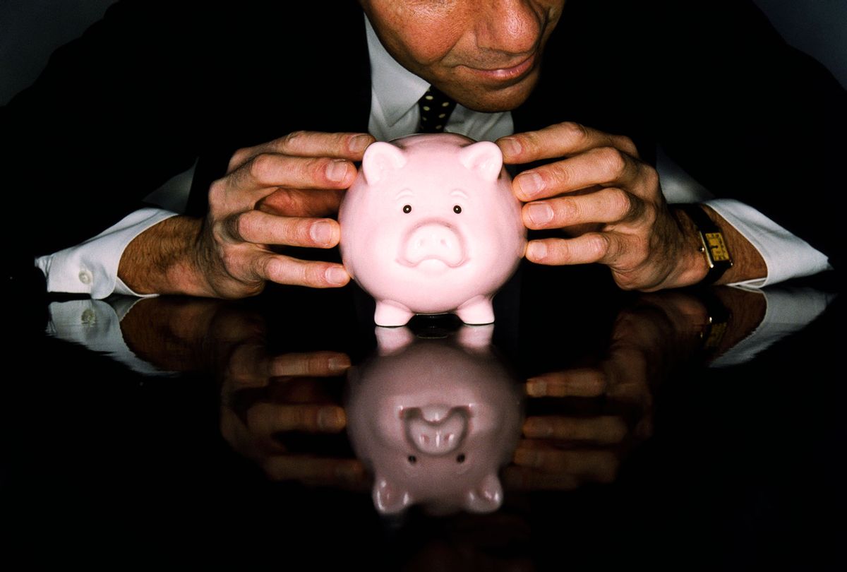 Businessman with Coin Bank (Getty Images)