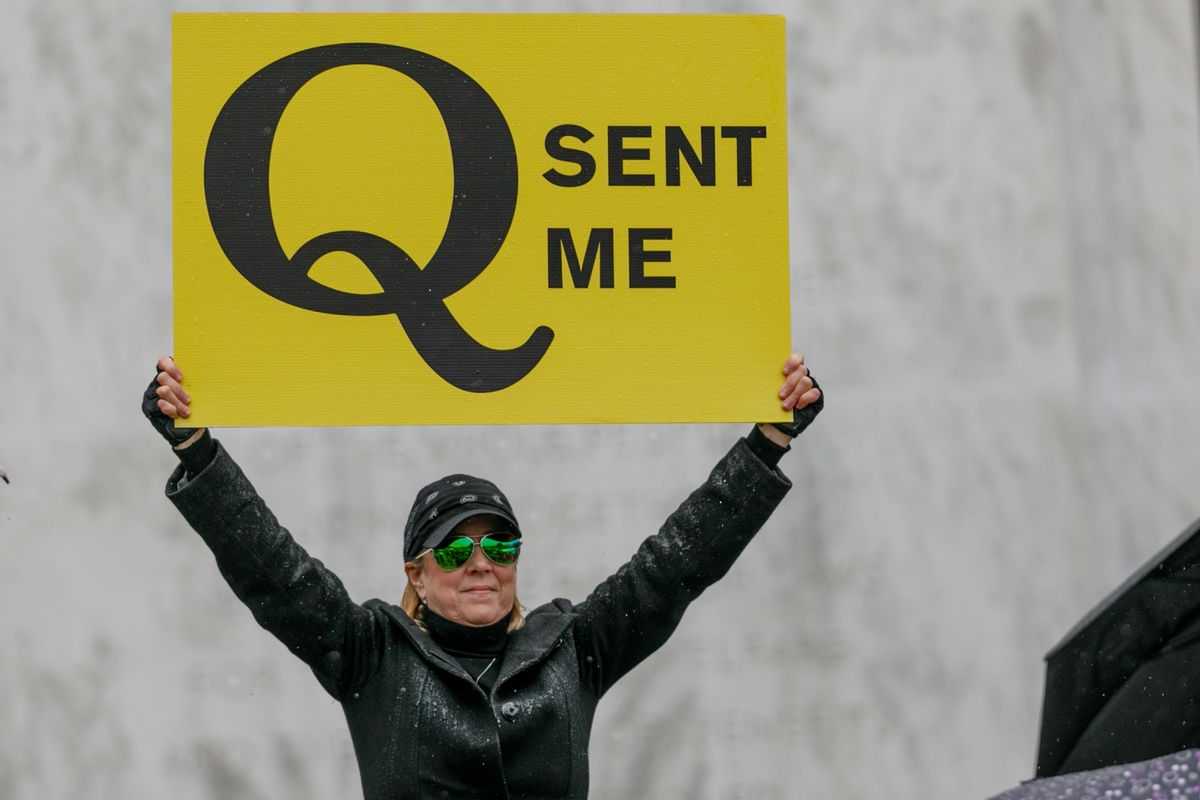 A QAnon supporter holds a sign during a protest at the Oregon State Capitol in Salem on May 2, 2020. (Getty Images)