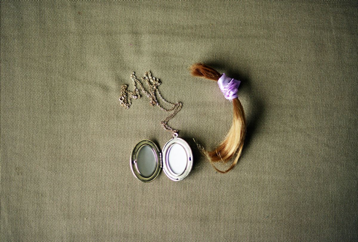 Lock of hair with purple ribbon and a locket necklace (Getty Images)