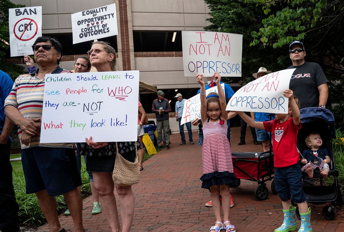 People hold up signs during a rally against "critical race theory" (CRT) being taught in schools at the Loudoun County Government center in Leesburg, Virginia on June 12, 2021. (ANDREW CABALLERO-REYNOLDS/AFP via Getty Images)