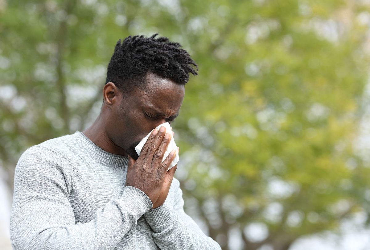 Allergic man blowing on wipe in a park on spring season a sunny day (Getty Images/Pheelings Media)