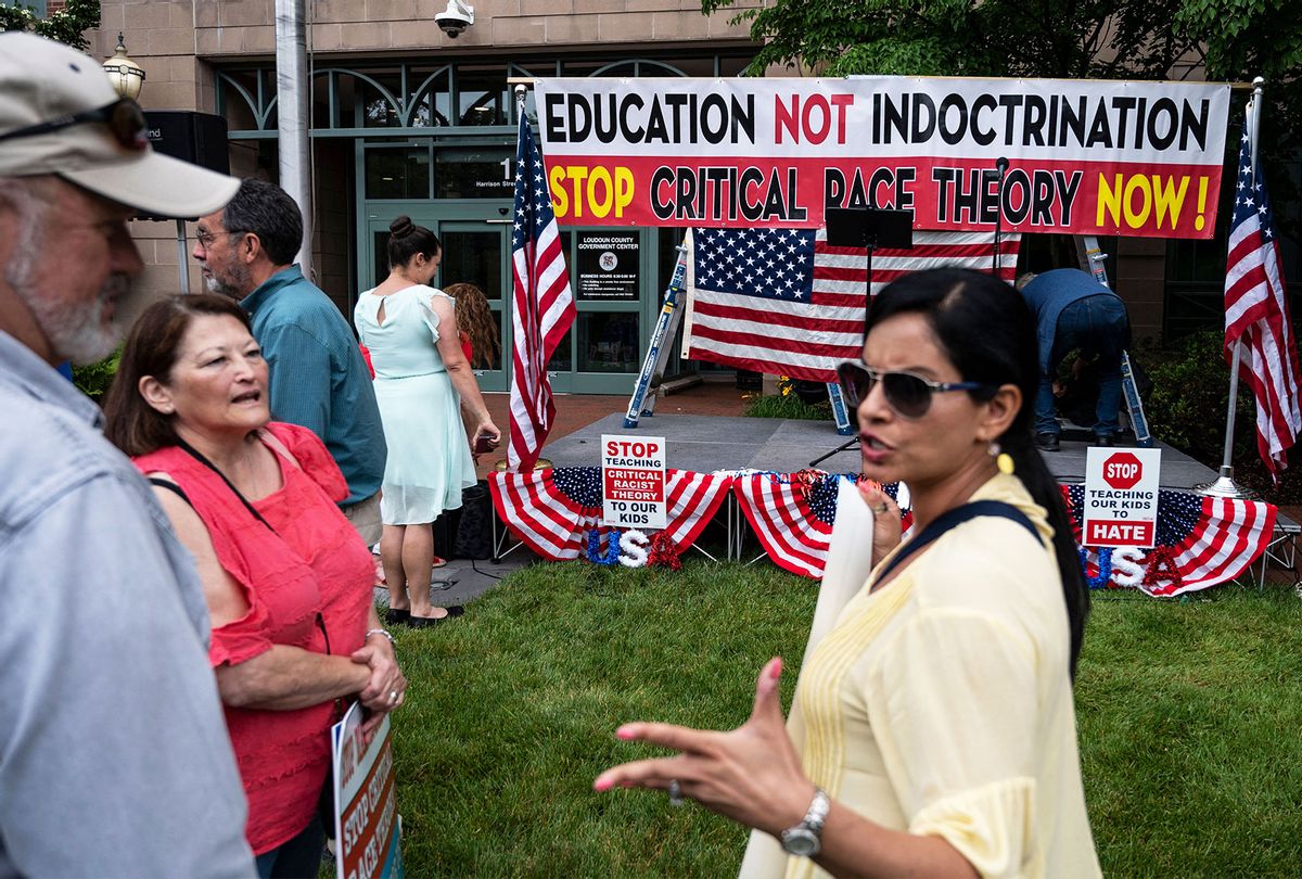 People hold up signs during a rally against "critical race theory" (CRT) being taught in schools at the Loudoun County Government center in Leesburg, Virginia on June 12, 2021.  (ANDREW CABALLERO-REYNOLDS/AFP via Getty Images)