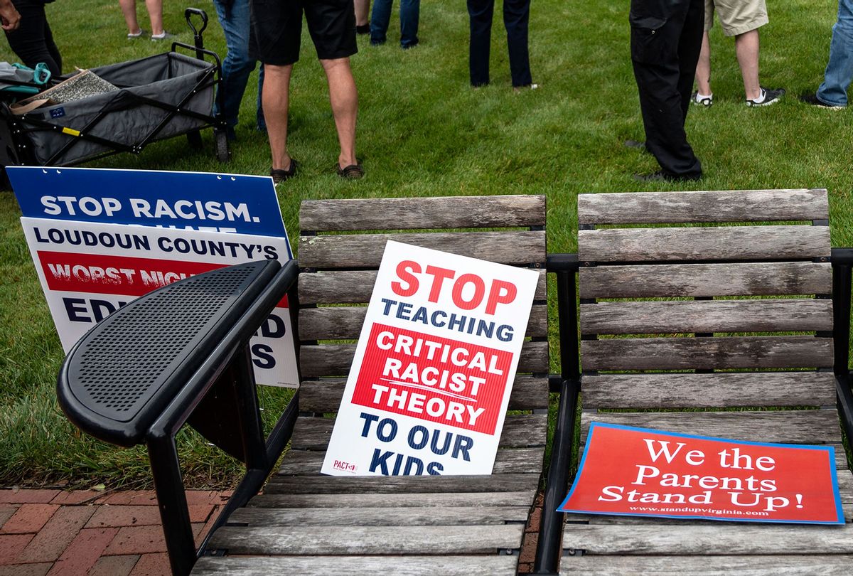 Signs are seen on a bench during a rally against "critical race theory" (CRT) being taught in schools at the Loudoun County Government center in Leesburg, Virginia on June 12, 2021. (ANDREW CABALLERO-REYNOLDS/AFP via Getty Images)