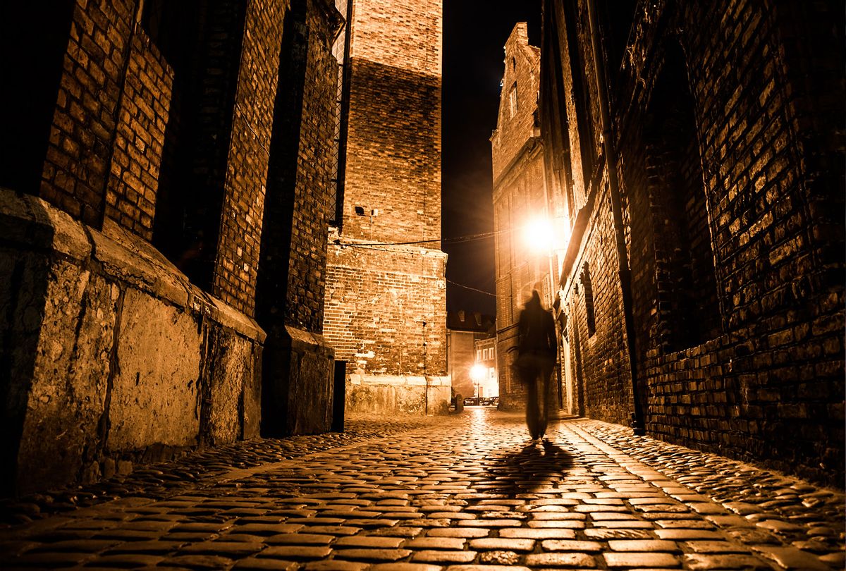 Illuminated cobbled street in old city by night (Getty Images/Pyty Czech)