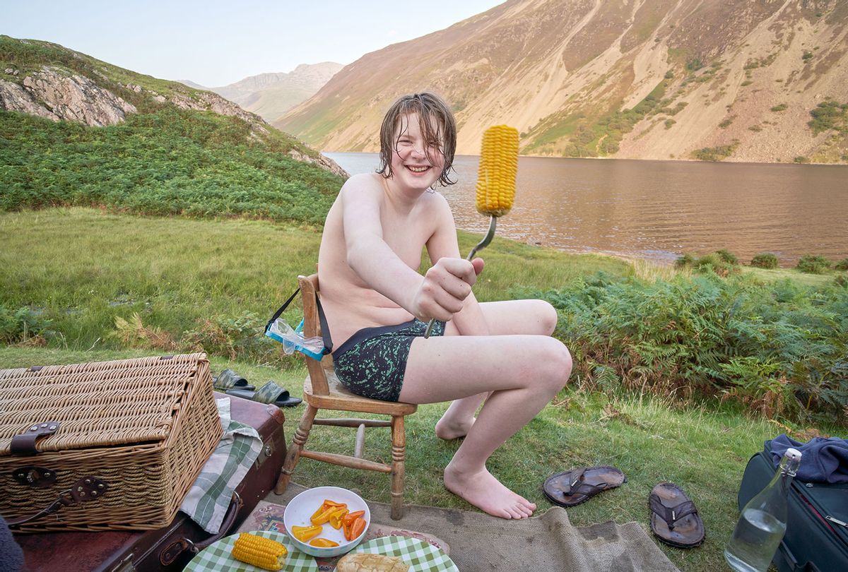 A teenage boy enjoying corn after swimming (Getty Images/Roy JAMES Shakespeare)