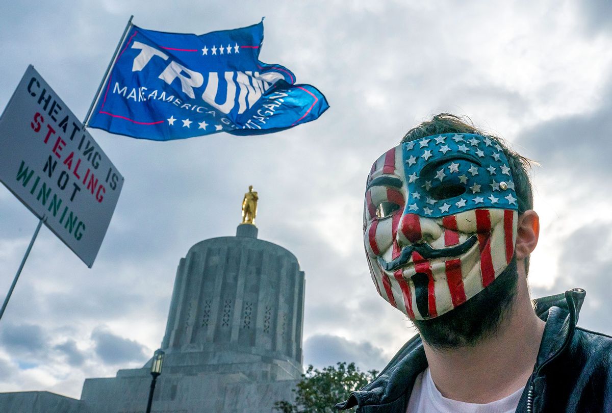 A protester in a Guy Fawkes mask stands in front of the Oregon State Capitol building during a Stop the Steal rally in Salem, Oregon. Angry supporters of President Trump took to the streets across the country following reporting that President-elect Joe Biden had won the election. (Nathan Howard/Getty Images)