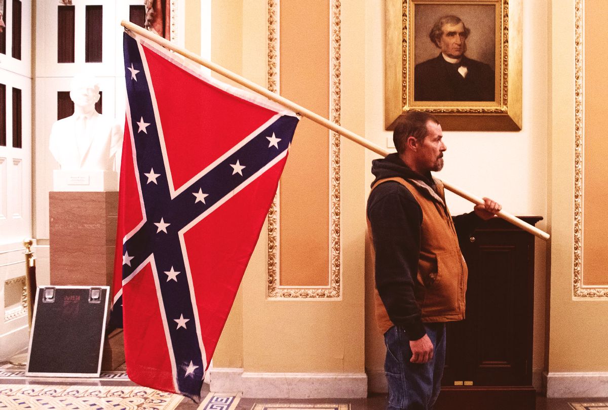 A supporter of US President Donald Trump holds a Confederate flag outside the Senate Chamber during a protest after breaching the US Capitol in Washington, DC, January 6, 2021. - The demonstrators breeched security and entered the Capitol as Congress debated the 2020 presidential election Electoral Vote Certification. (SAUL LOEB/AFP via Getty Images)