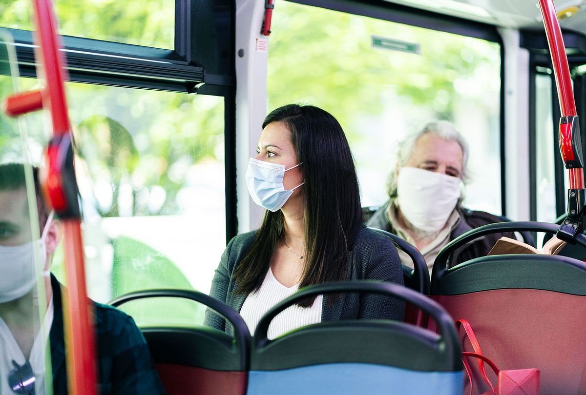 Woman wearing protective mask sitting in bus (Getty Images)