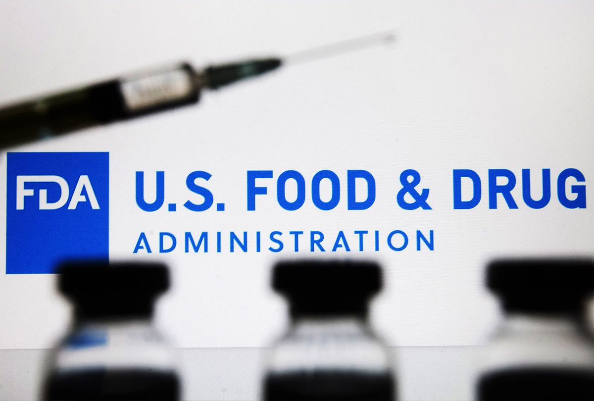 Vials and a medical syringe seen displayed in front of the Food and Drug Administration (FDA) of the United States logo. FDA finds the COVID-19 vaccine. (Photo Illustration by Pavlo Gonchar/SOPA Images/LightRocket via Getty Images)