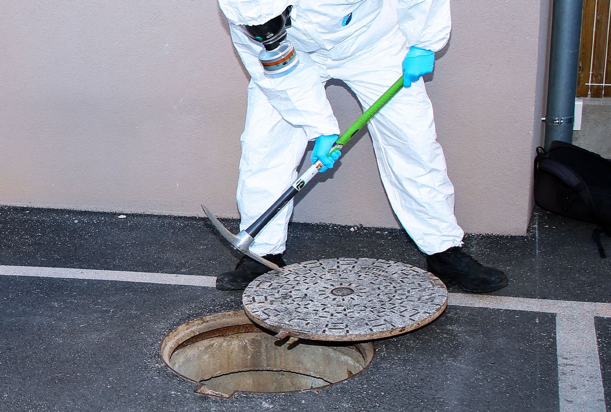 A health worker wearing a personal protective equipment suit (PPE) take the cover off a manhole for inspection in Marseille. The COMETE unit (Covid Marseille Environmental Testing Expertise) collects samples of wastewater at various points in the city to determine the neighborhoods, schools or certain buildings contaminated by Covid-19 through testing of these samples. (Denis Thaust/SOPA Images/LightRocket via Getty Images)