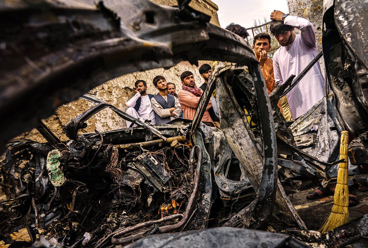 Relatives and neighbors of the Ahmadi family gathered around the incinerated husk of a vehicle targeted and hit earlier Sunday afternoon by an American drone strike, in Kabul, Afghanistan, Monday, Aug. 30, 2021. (Getty Images/MARCUS YAM/LOS ANGELES TIMES)