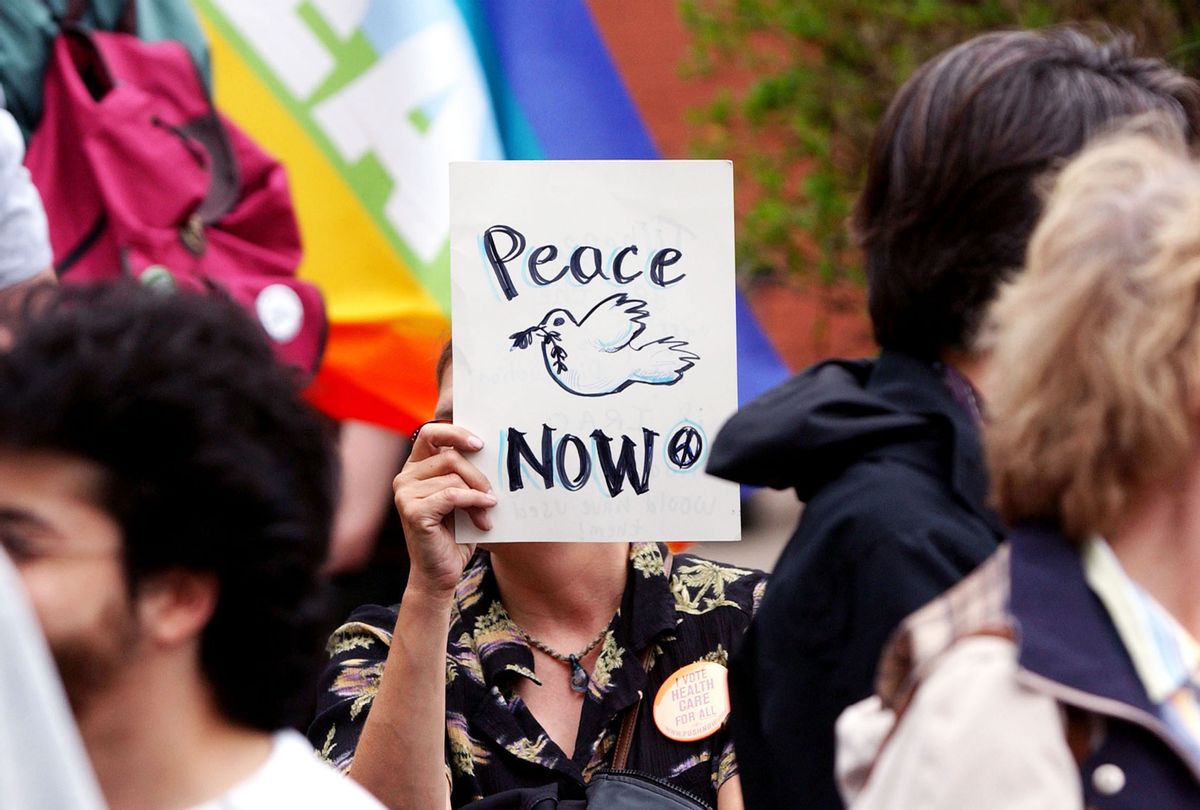 A peace activist holds a peace sign (Jeff Swensen/Getty Images)