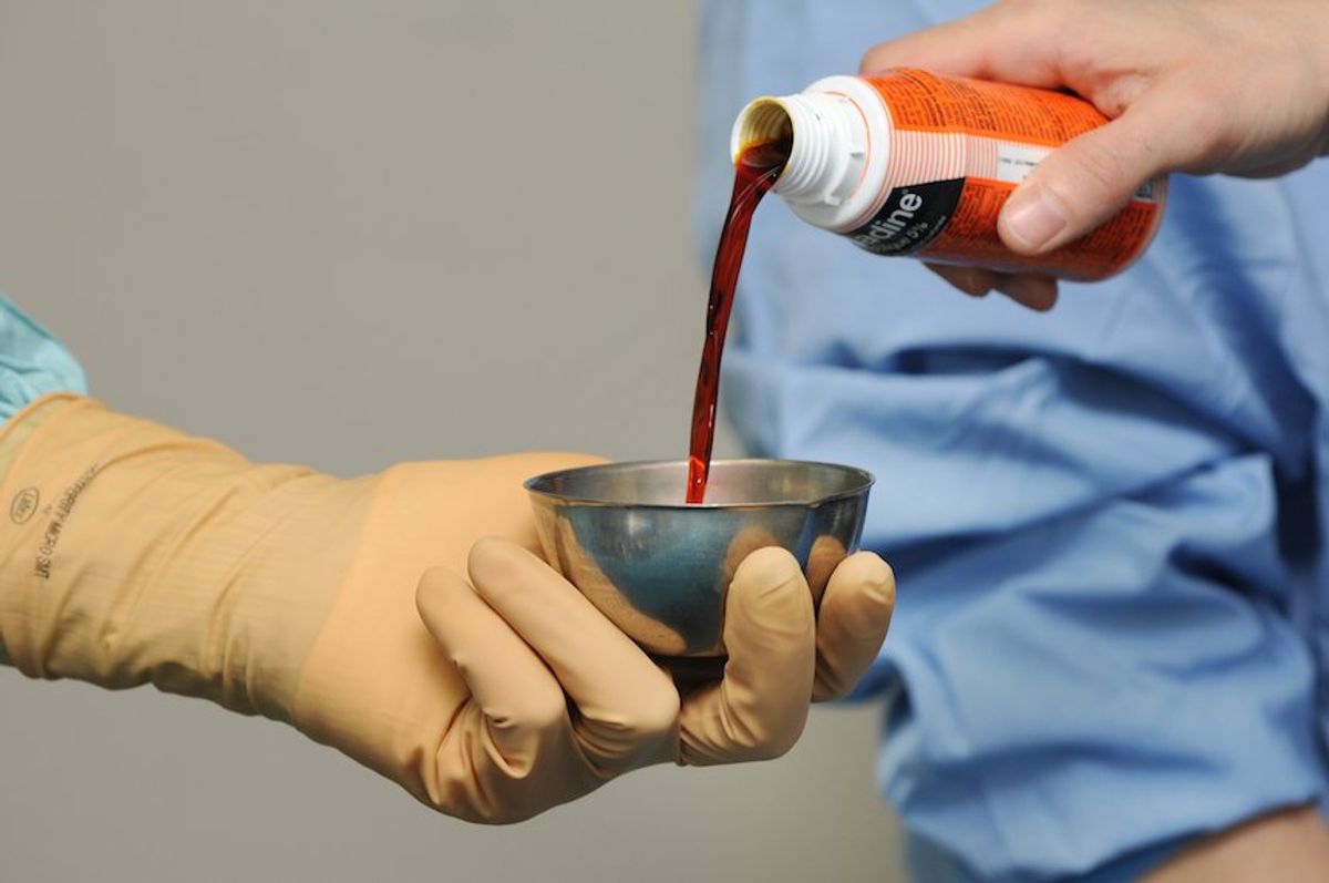 Betadine being poured into a metal vessel (BSIP/Universal Images Group via Getty Images)
