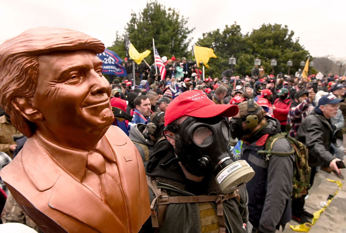 A supporter of US President Donald Trump wears a gas mask and holds a bust of him after he and hundreds of others stormed stormed the Capitol building on January 6, 2021 in Washington, DC. (ROBERTO SCHMIDT/AFP via Getty Images)