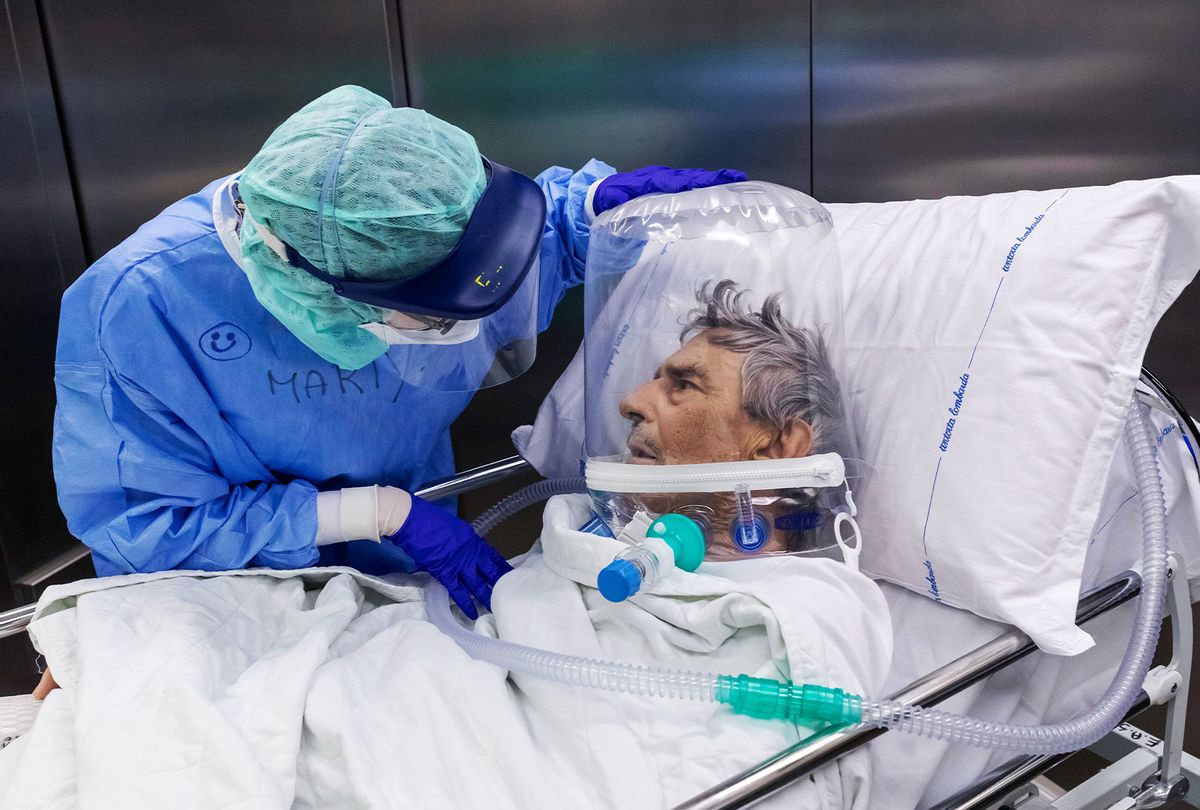 A nurse attends to a COVID-19 patient that is wearing a CPAP helmet while he is moved out of the Intensive Care Unit (ICU) of the Pope John XXIII Hospital on April 7, 2020 in Bergamo, Italy. (Marco Di Lauro/Getty Images)