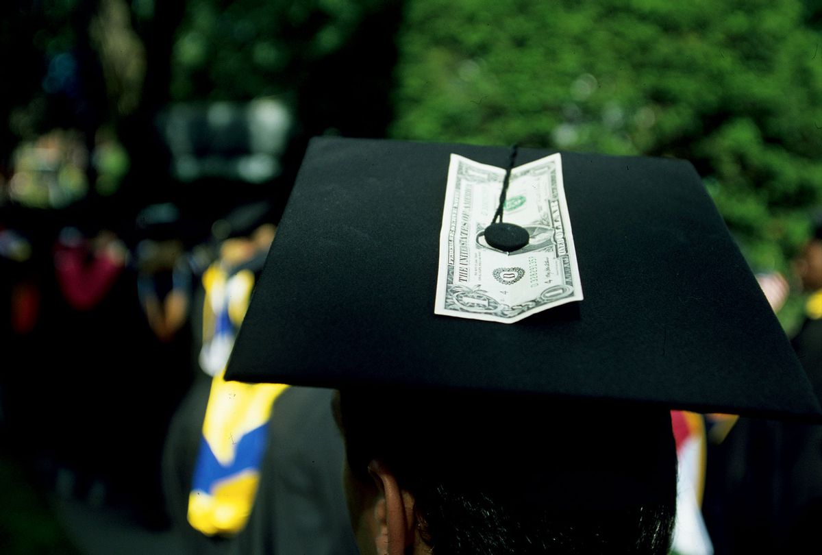 A student with a dollar bill attached to his cap during the graduation ceremony. (Brooks Kraft LLC/Corbis via Getty Images)