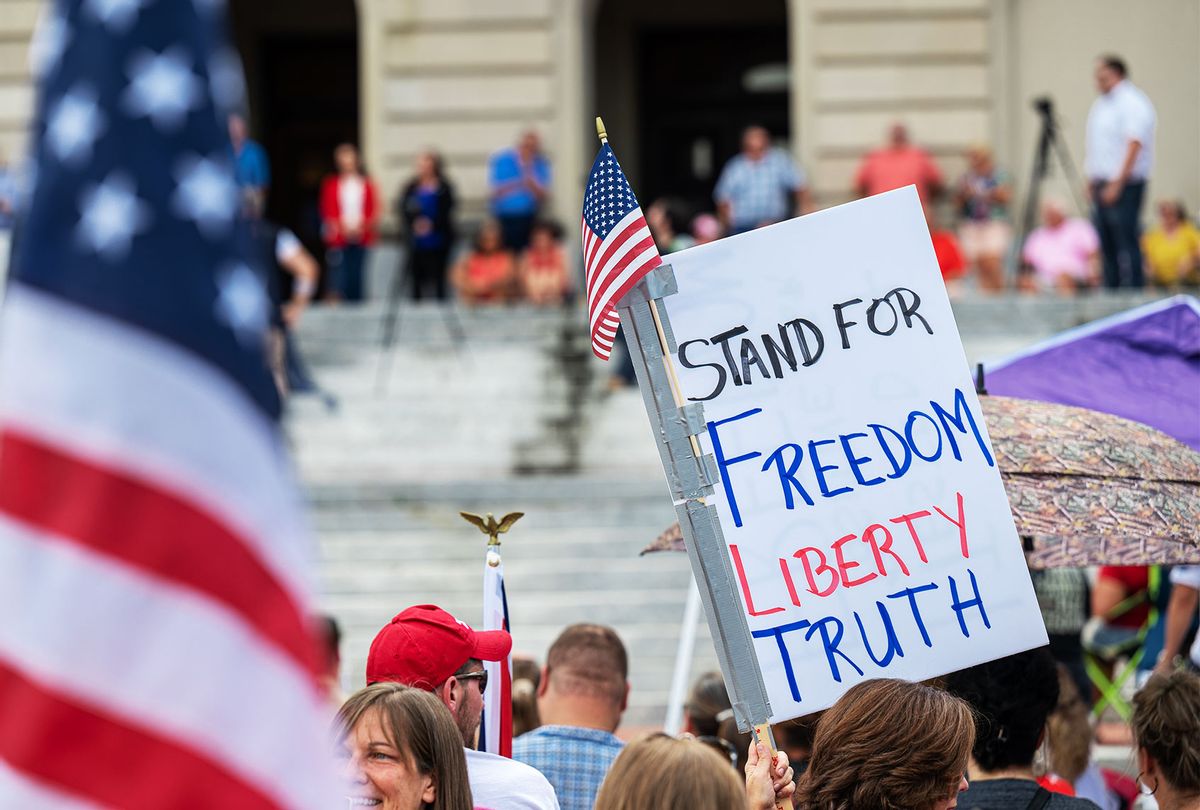 People display signs during the Kentucky Freedom Rally at the capitol building on August 28, 2021 in Frankfort, Kentucky. (Jon Cherry/Getty Images)