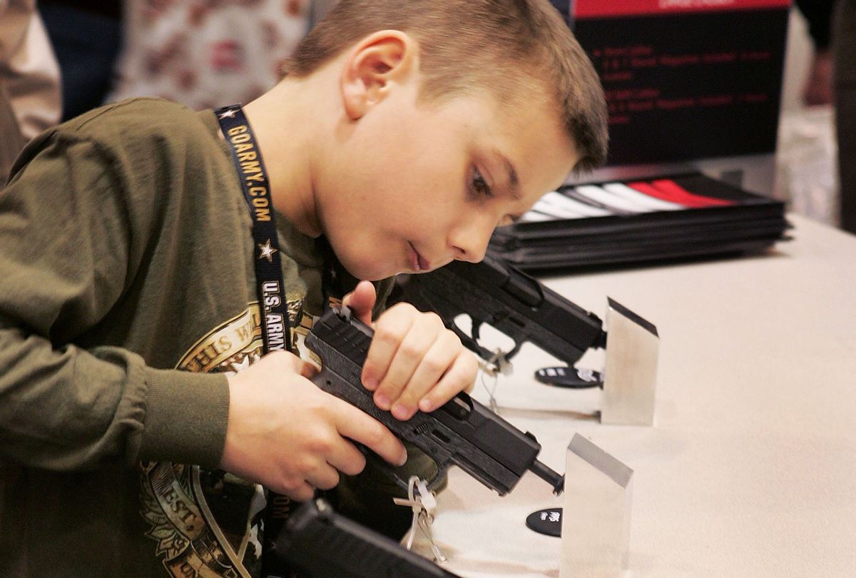 Eight-year-old Dakota Stevenson looks over Walthers pistols at the Smith & Wesson booth during the 136th NRA Annual Meetings and Exhibits April 13, 2007 in St. Louis, Missouri. (Scott Olson/Getty Images)
