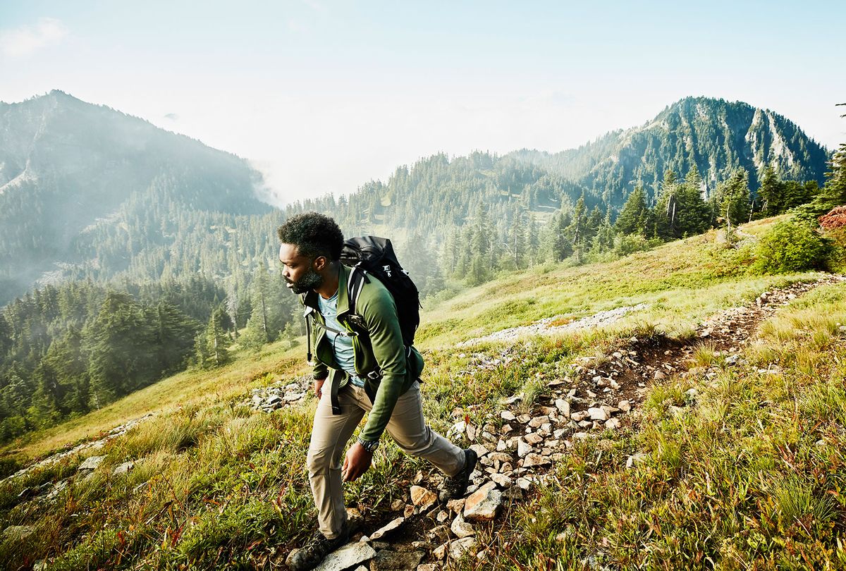 Man on early morning hike up mountainside (Getty Images/Thomas Barwick)