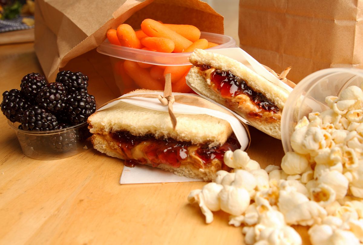 A peanut butter and jelly sandwich surrounded by several other food items that would make up a child's lunch. (Getty Images/steele2123)