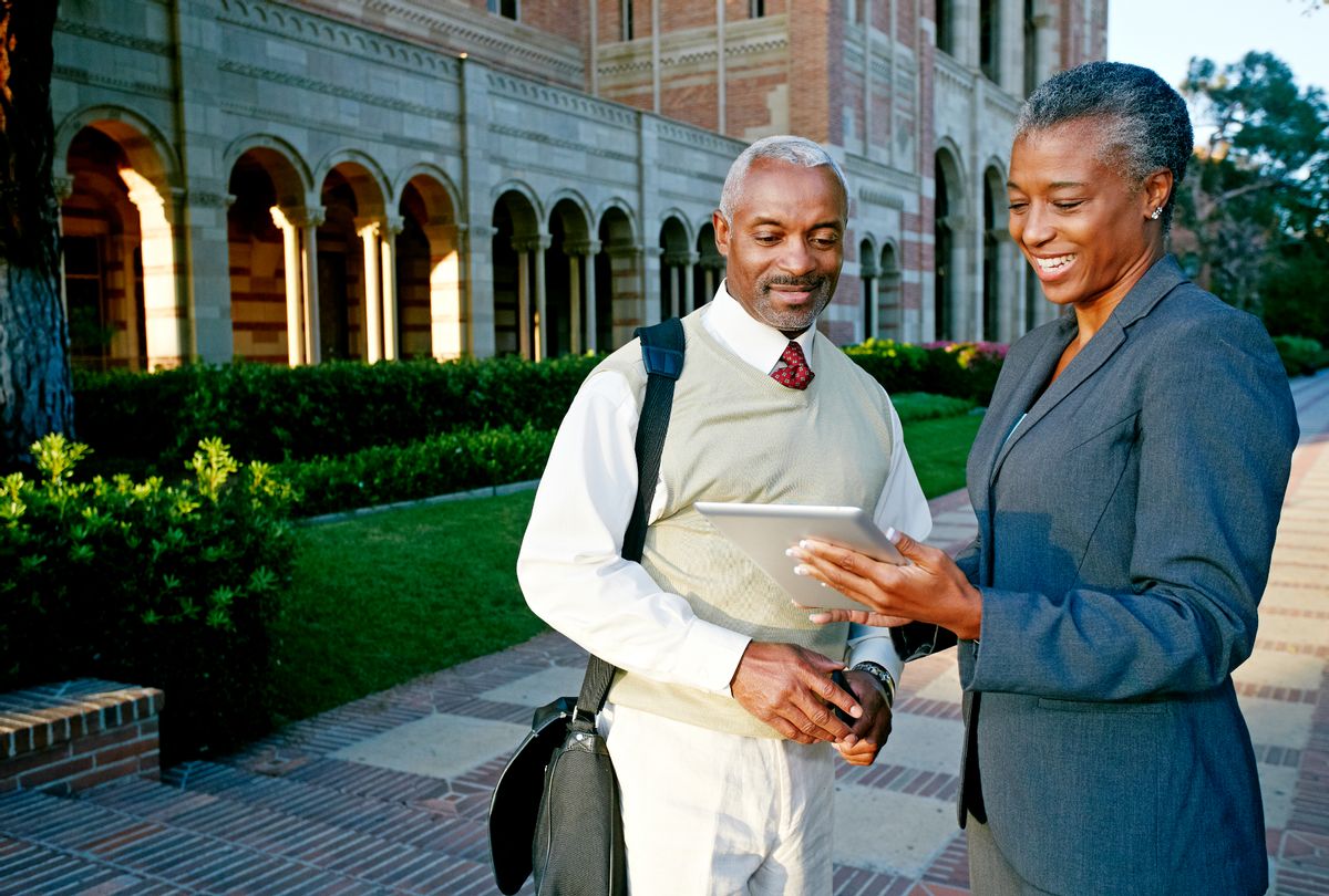 Professors on campus looking at a tablet (Getty stock photos)