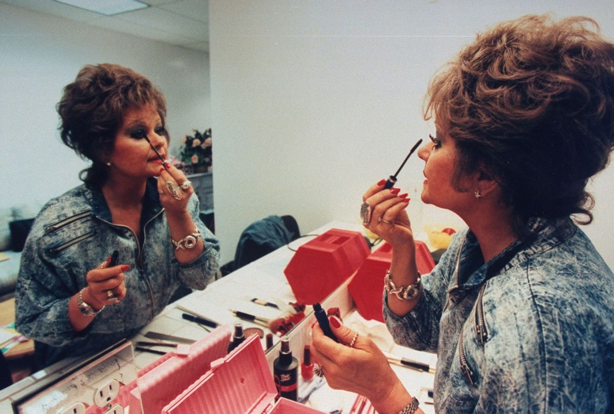 TV talk show host Tammy Faye Bakker Messner applying mascara to eyelashes in mirror in dressing room (John Storey/Getty Images)