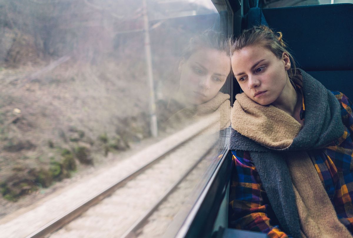 Woman looks outside a train window while traveling﻿﻿ (Getty Images/Mixmike)