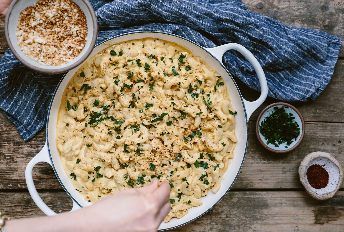 Sprinkling breadcrumbs on a big pot of mac and cheese (Getty Images/The Picture Pantry)