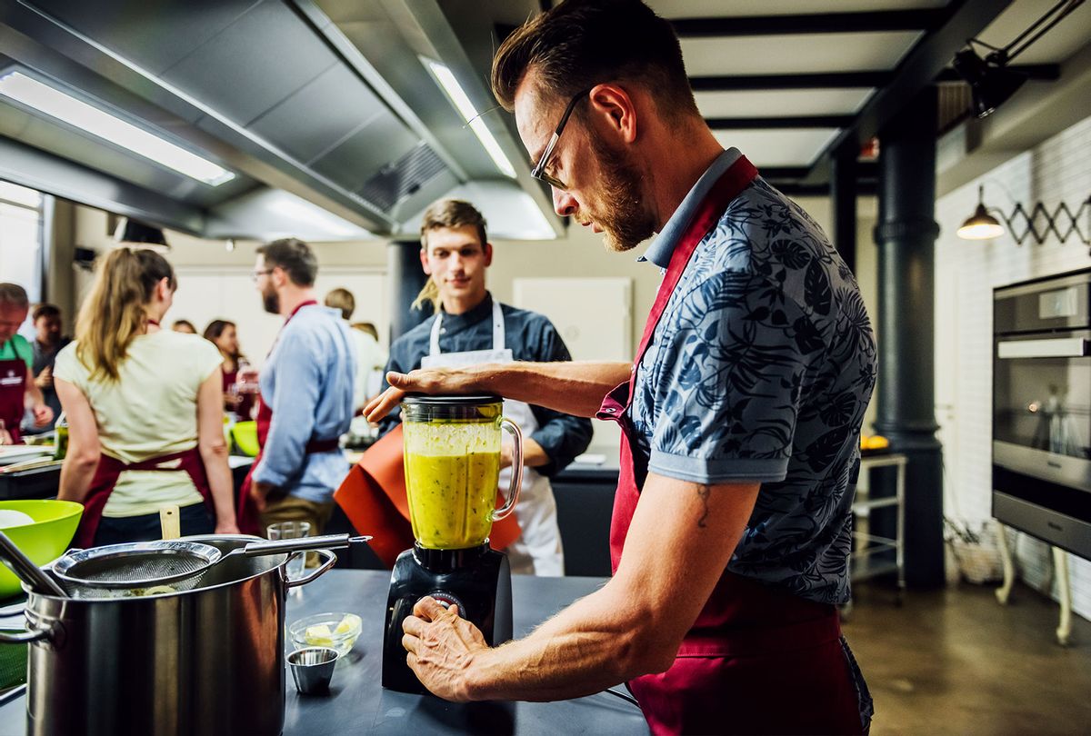 Man in cooking class mixing food in blender (Getty Images/Hinterhaus Productions)