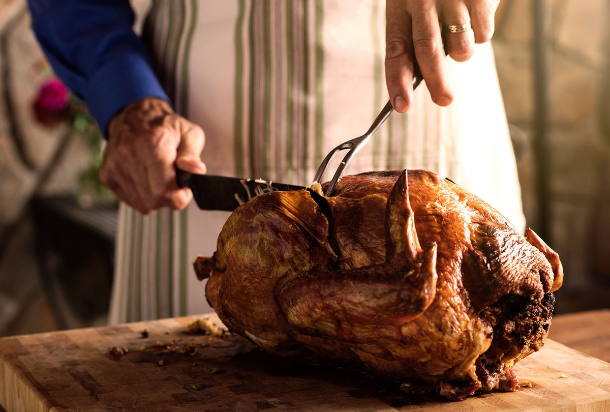 Man carving a fresh roasted turkey (Getty Images/The Good Brigade)