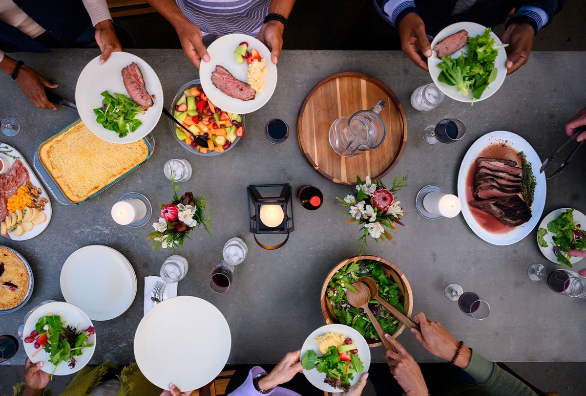 Overhead view of friends eating dinner outdoors (Getty Images/The Good Brigade)