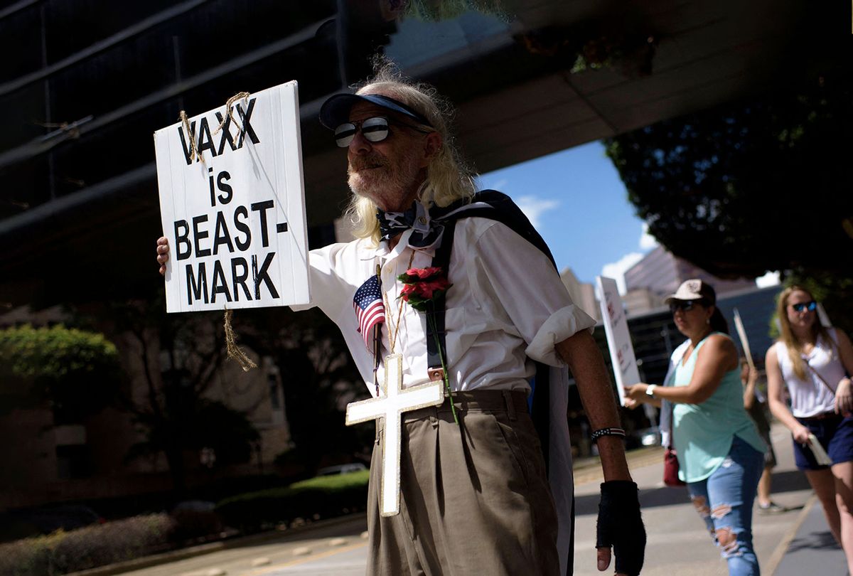 Anti-vaccine rally protesters hold signs outside of Houston Methodist Hospital in Houston, Texas, on June 26, 2021 (MARK FELIX/AFP /AFP via Getty Images)