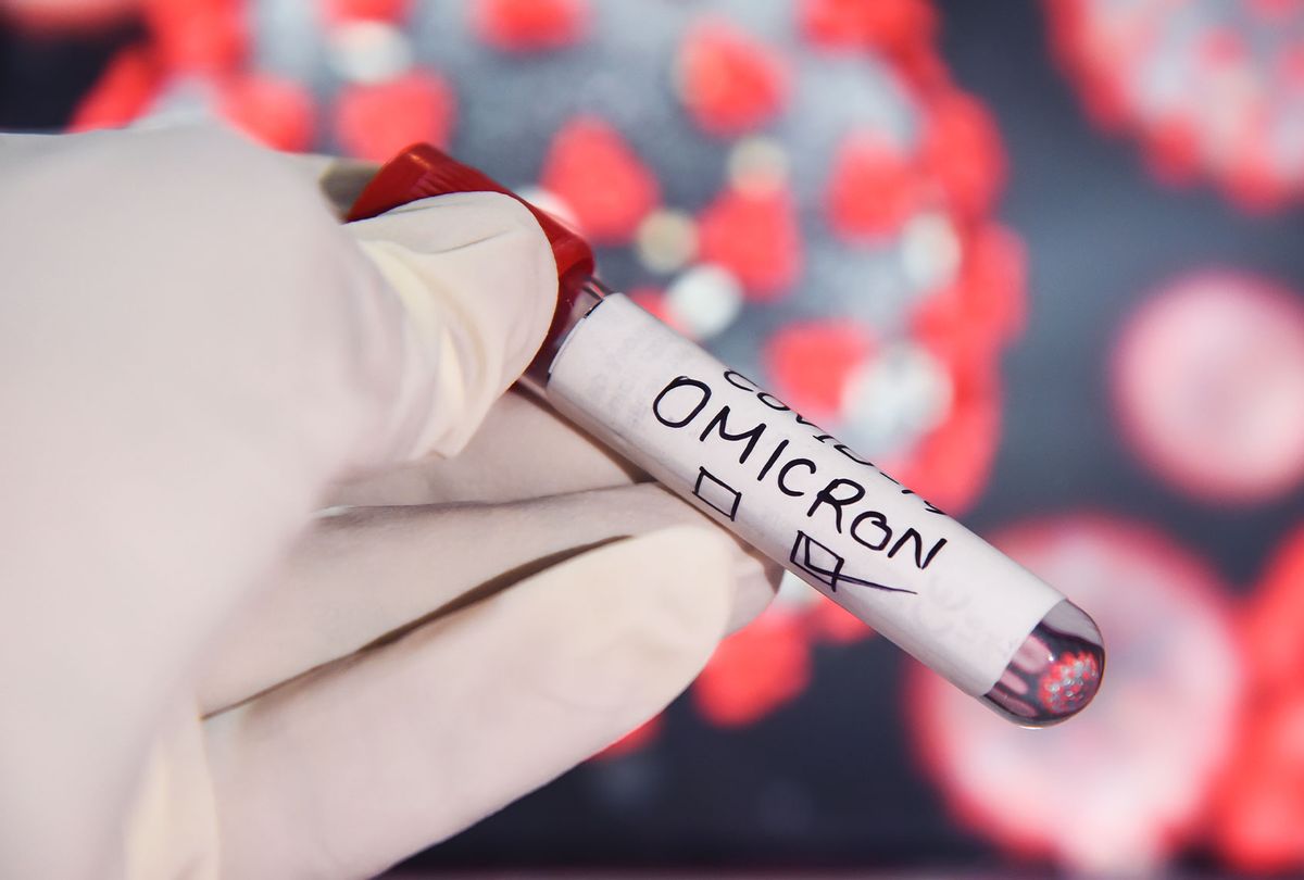 A health worker wearing gloves holding a test sample tubes labeled 'COVID-19 Omicron' (Getty Images/David Talukdar)