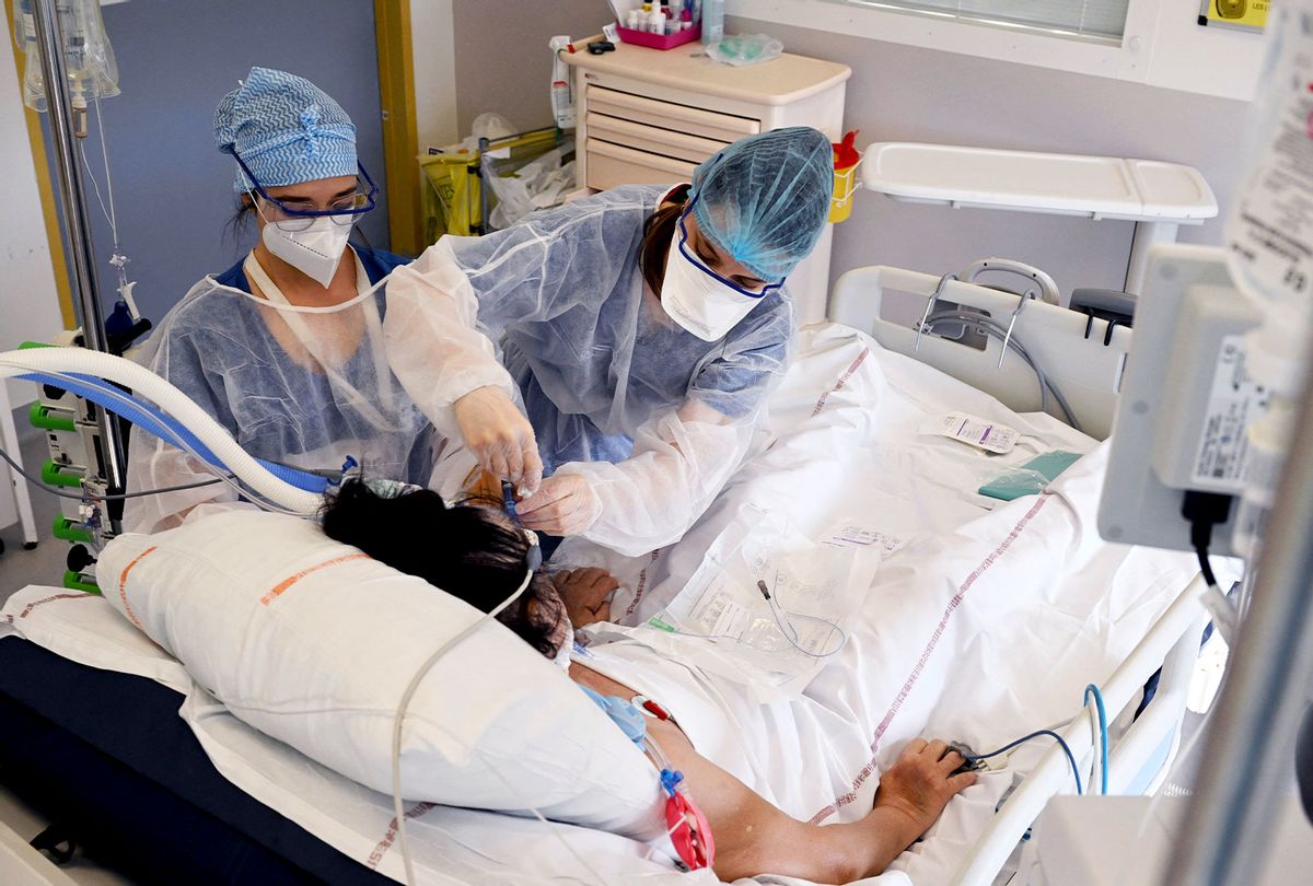 Nurses take care of a patient infected with the Covid-19 at the intensive care unit of the Timone hospital, in Marseille, southern France on January 5, 2022. (NICOLAS TUCAT/AFP via Getty Images)