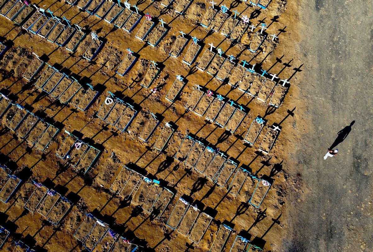 Aerial view showing a man walking past graves in the Nossa Senhora Aparecida cemetery in Manaus on June 21, 2020. - The novel coronavirus has killed at least 464,423 people worldwide since the outbreak began in China last December, being Brazil Latin America's worsthit country with 49,976 deaths from 1,067,579 cases. (MICHAEL DANTAS/AFP via Getty Images)