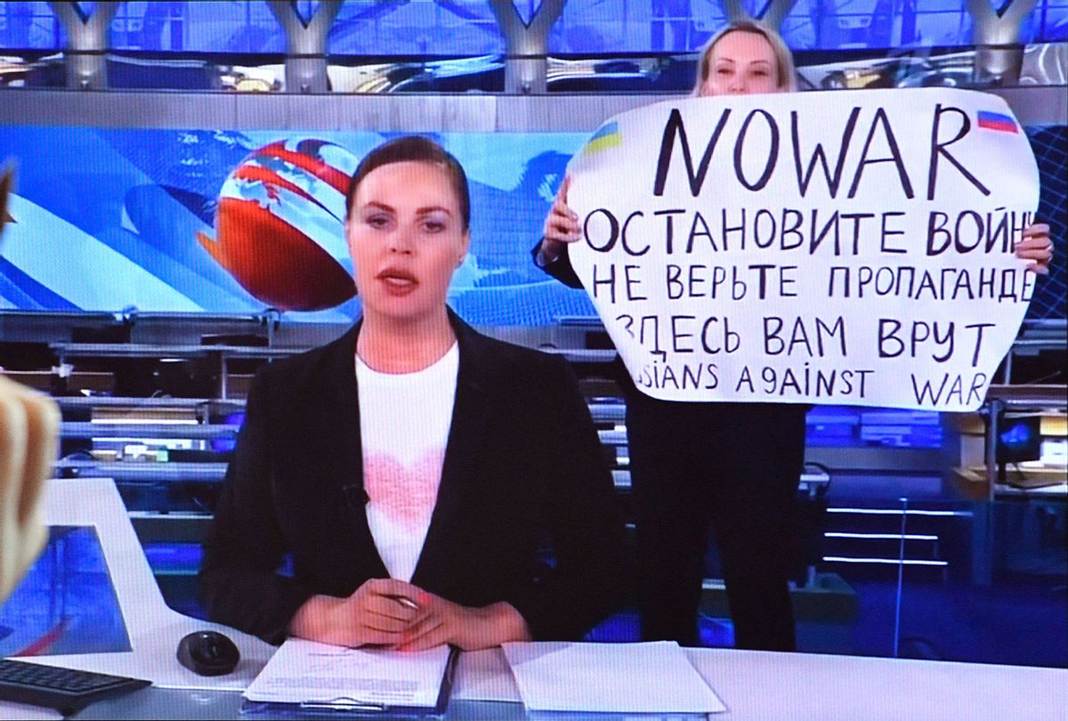 A woman looks at a computer screen watching a dissenting Russian Channel One employee entering Ostankino on-air TV studio during Russia's most-watched evening news broadcast, holding up a poster which reads as "No War" and condemning Moscow's military action in Ukraine in Moscow on March 15, 2022. - As a news anchor Yekaterina Andreyeva launched into an item about relations with Belarus, Marina Ovsyannikova, who wore a dark formal suit, burst into view, holding up a hand-written poster saying "No War" in English. (AFP via Getty Images)