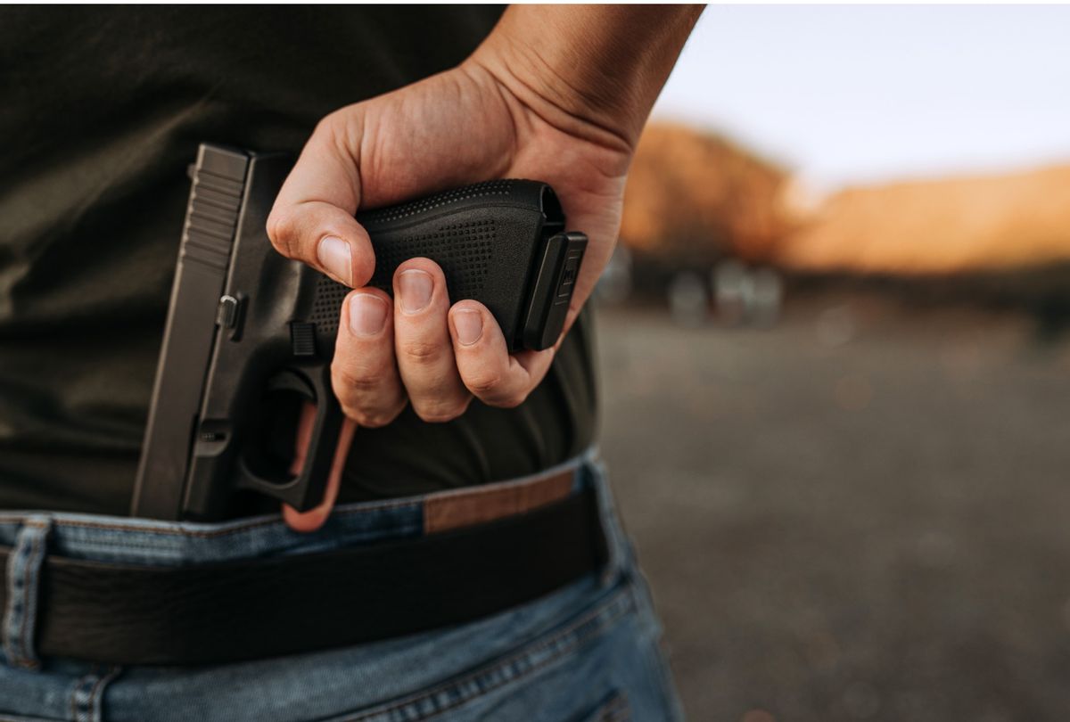 Man holding hidden gun in his hand. (Getty Images)