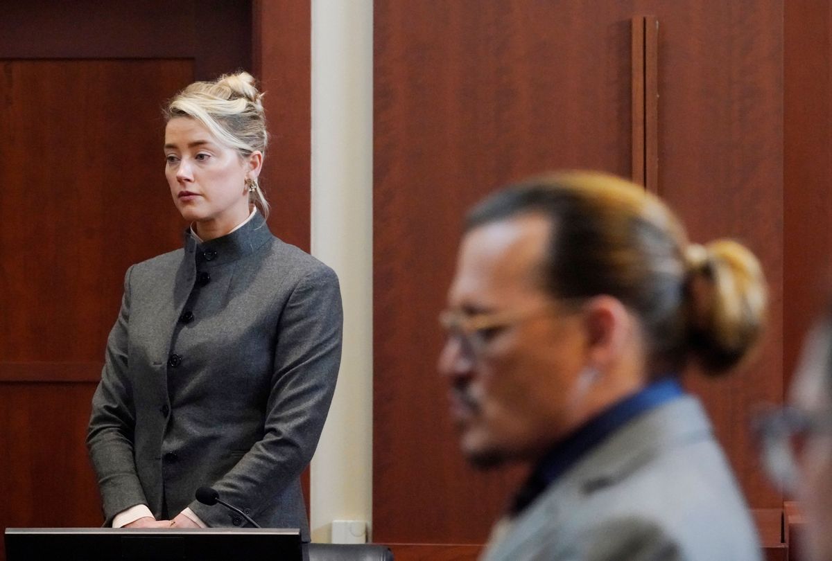 Amber Heard and Johnny Depp watch as the jury leave the courtroom for a lunch break at the Fairfax County Circuit Courthouse in Fairfax, Virginia, on May 16, 2022 (STEVE HELBER/POOL/AFP via Getty Images)
