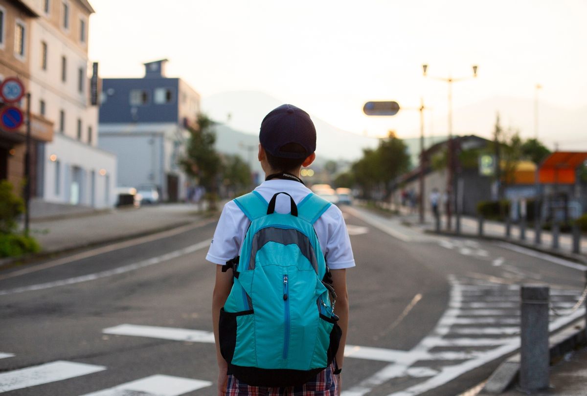 Boy with a teal backpack looking at the sunset (PHOTO MIO JAPAN/Getty)