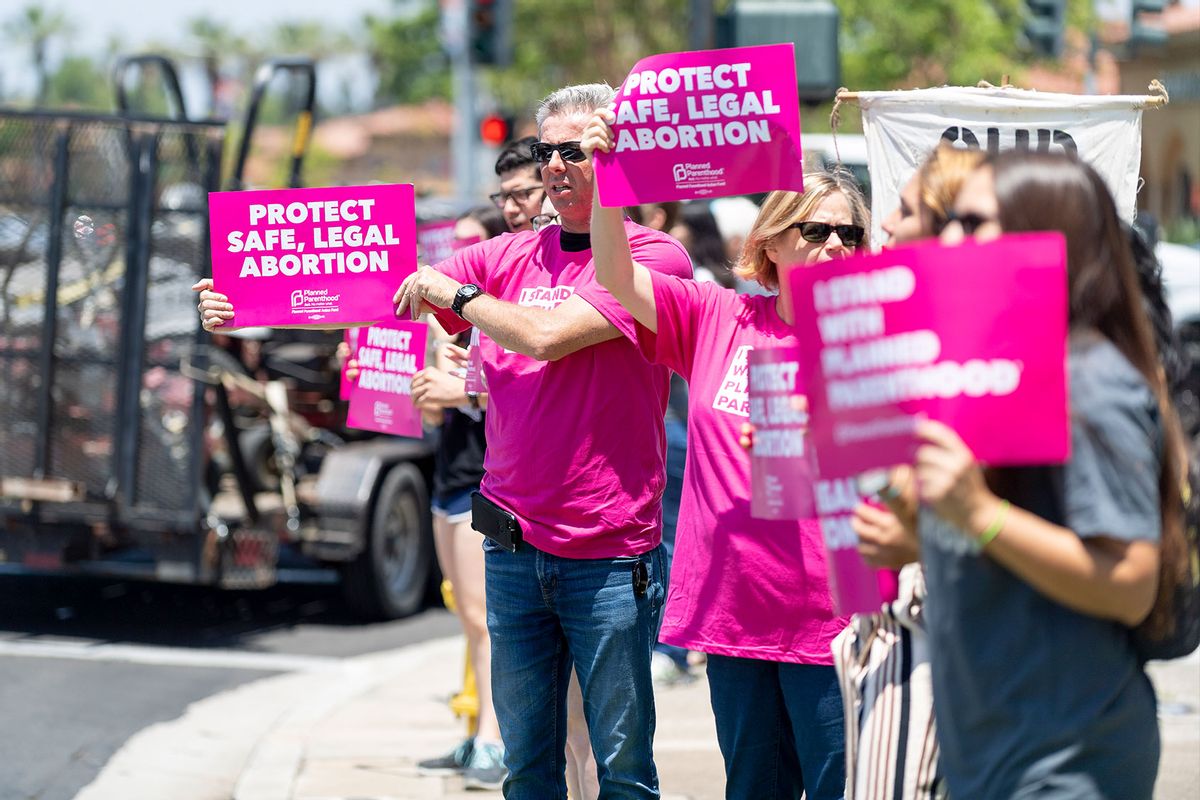 Protestors hold signs during Stop the Bans Speak Out Tour at the corner of Culver Drive and Alton Parkway in Irvine, CA on Wednesday, June 19, 2019. (Paul Bersebach/MediaNews Group/Orange County Register via Getty Images)